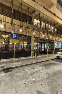 cars parked outside of a building with an awning on the outside and metal scaffolding above