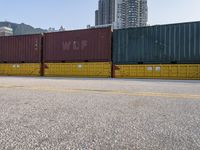 a parking lot has a bunch of containers on it's sides, and the end of a car