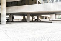 a large white building with windows and a tiled courtyard outside it is covered in many different designs