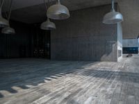 a very large wood floor in a building near some large lights on either side of the building