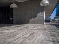 a very large wood floor in a building near some large lights on either side of the building