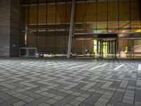 the empty floor in front of a building has geometric pattern tiles on it and windows