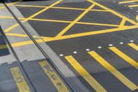 a yellow crosswalk that is in the street and a car parked on it with a window open