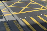 a yellow crosswalk that is in the street and a car parked on it with a window open