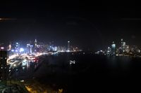 city lights on a hazy night by the water with a boat in the foreground