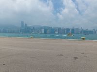 an airplane that is flying over the water next to a beach and city skylines