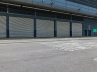 a parking area that has a closed garage with an entrance and two shuttered doors