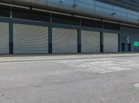 a parking area that has a closed garage with an entrance and two shuttered doors