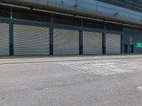 a parking area that has a closed garage with an entrance and two shuttered doors