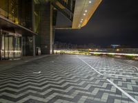 a black and white square on a brick floor with lights above it on an outdoor platform