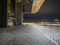 a black and white square on a brick floor with lights above it on an outdoor platform