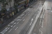 an overhead view of a city street with people walking on the sidewalks and two empty busses