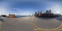 a 360 - fish eye view of a wide harbor area with buildings in the distance