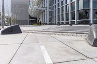 stone benches on a concrete square in front of a building that is very tall in a city