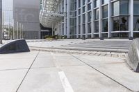 stone benches on a concrete square in front of a building that is very tall in a city