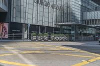 yellow lines painted on the street of a city street with people walking around and parked motorcycles next to them