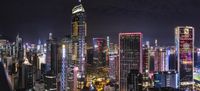 a view from the top of a skyscraper building with many tall buildings lit up in purple and red