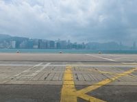 empty runway with cityscape in background and blue sky and clouds above them in hong kong kong