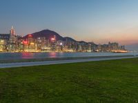 this picture is an image of a night view of hong's victoria skyline, with the lights glowing in red on the buildings