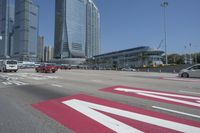 cityscape in the background with tall buildings on either side of the road and cars driving