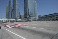 cityscape in the background with tall buildings on either side of the road and cars driving