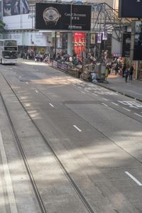two trains running along the train tracks near a building and street with a bicycle in the distance