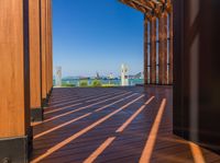 an empty wooden deck with a view to the water and city below it in this image