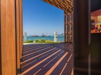 an empty wooden deck with a view to the water and city below it in this image