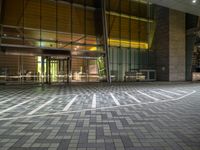 a photo of an open area inside a building at night with sunlight streaming in through the glass windows