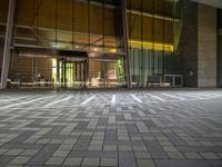 a photo of an open area inside a building at night with sunlight streaming in through the glass windows