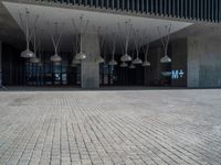 the front entrance to the main building of this modern building, with many lamps hanging from the ceiling