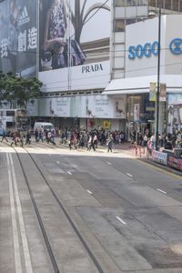 two trains running along the train tracks near a building and street with a bicycle in the distance