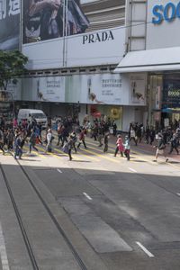two trains running along the train tracks near a building and street with a bicycle in the distance