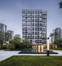 the exterior and grounds of an apartment building at dusk in hong's central business district