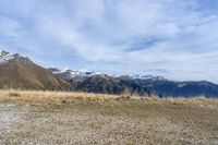 a horse grazing on grass next to mountains with snow capped peaks behind it and a sign that says the turn is now