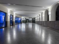 the interior of a hospital lobby with blue light on the doors and windows as well as lights