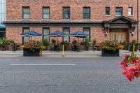 a hotel on a corner near a flower display in the street and outside with red roses