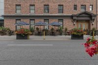 a hotel on a corner near a flower display in the street and outside with red roses