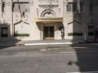 the entrance to the hotel has many large flags flying from it's front door