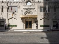 the entrance to the hotel has many large flags flying from it's front door