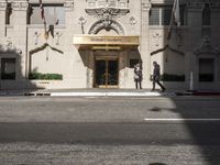 the entrance to the hotel has many large flags flying from it's front door