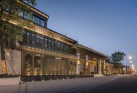 the entrance of the hotel at night, lit with outdoor lighting and landscaping by design group