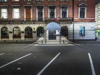 a building with a umbrella sitting in the street next to it and a fence behind it