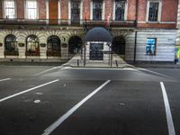 a building with a umbrella sitting in the street next to it and a fence behind it