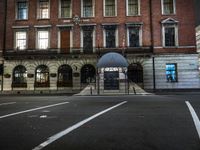 a building with a umbrella sitting in the street next to it and a fence behind it