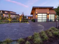 a large garage is shown outside in this picture to the side of the house with driveway leading up to it