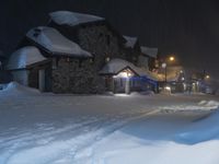 a large group of snow covered buildings in the street at night on a snowy day