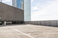 an empty parking lot that has some buildings on the other side of it and a parking area in front of it