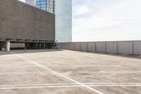 an empty parking lot that has some buildings on the other side of it and a parking area in front of it