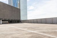 an empty parking lot that has some buildings on the other side of it and a parking area in front of it